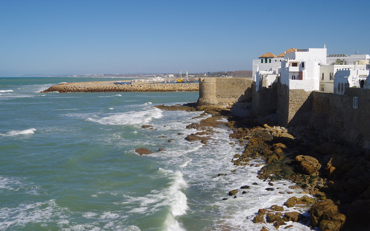 Waves crash against a breakwater made of city wall