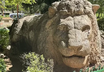 A stone lion sculpture in a garden