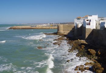 Waves crash against a breakwater made of city wall