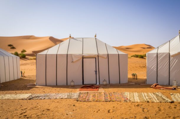 The white Berber tents in the Sahara Desert, Morocco with carpets on the sandy ground
